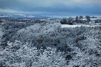 Aerial view of snow covered landscape against sky