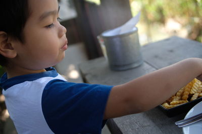 Close-up of boy with snack at table