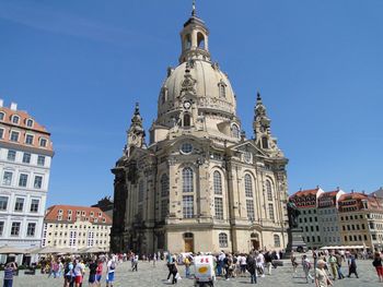 Tourists in front of church against sky