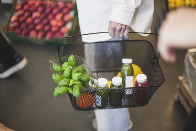 High angle view of woman carrying food basket in store