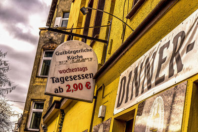 Low angle view of information sign against sky