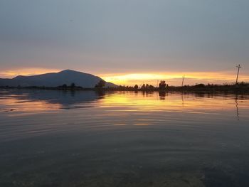 Scenic view of lake against sky during sunset