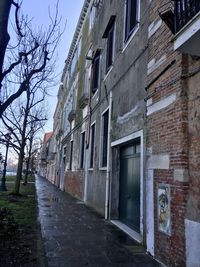 Footpath amidst buildings against sky in city