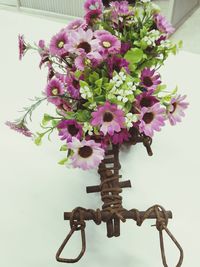 Close-up of pink flower pot on table against wall