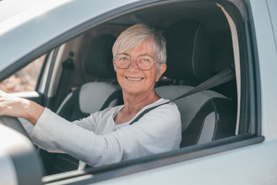 Portrait of young woman sitting in car
