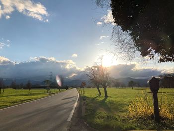 Road amidst field against sky