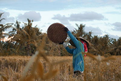 Farmer winnowing on agricultural field