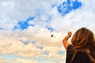 Girl flying kite against sky