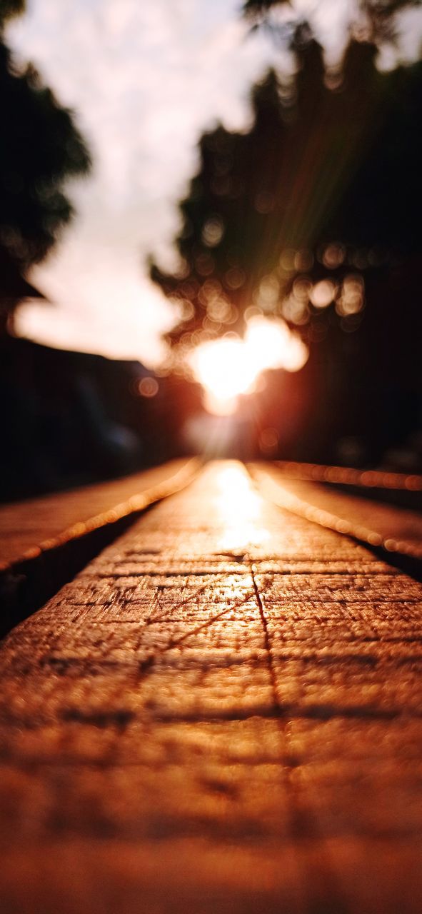 SURFACE LEVEL OF WOODEN WALKWAY AGAINST SKY