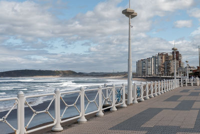 Street by sea against sky in city