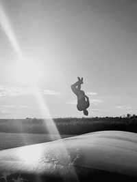 Man jumping on road against sky