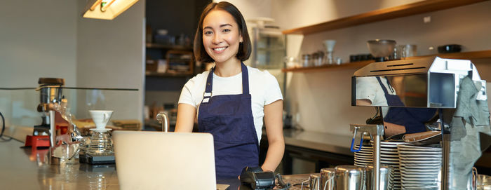 Portrait of young woman standing in cafe