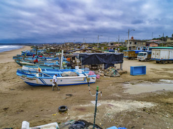 Boats moored on beach against sky