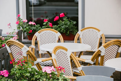 Empty chairs and tables at sidewalk cafe