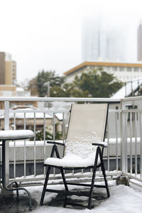 Close-up of chairs and table against trees