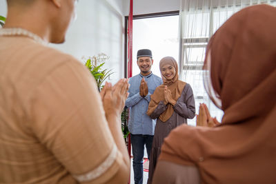 Man and woman with hands clasped standing at home