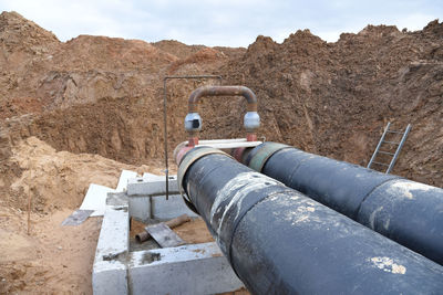 Laying heating pipes in a trench at construction site. 