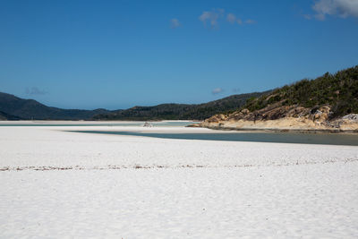 Scenic view of beach against blue sky