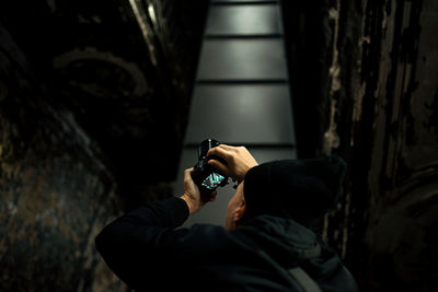 Low angle view of young man photographing with camera at night