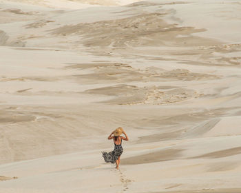 Rear view of woman walking on beach