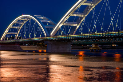 View of bridge over river at night