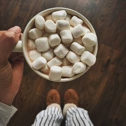 Hand holding marshmallows in cup