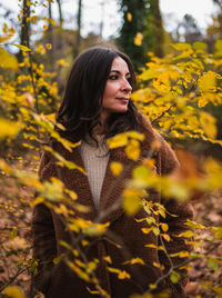 Young woman standing amidst yellow flower