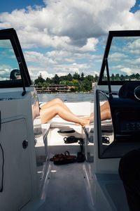 Woman's legs lounging on deck of motorboat during a sunny day on the lake