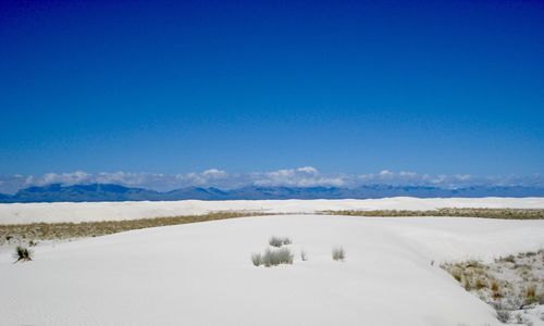 Scenic view of snowcapped mountains against clear blue sky