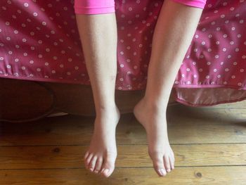 Low section of woman standing on hardwood floor