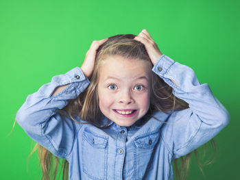 Angry girl against green background