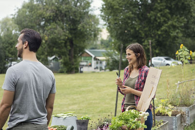 Mid adult couple selling vegetables at urban garden