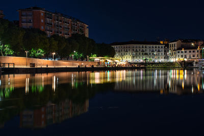 Reflection of buildings in lake at night