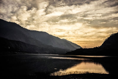 Scenic view of lake against cloudy sky