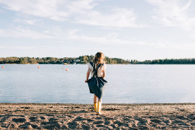 Girl running towards the sea in a dress at sunset