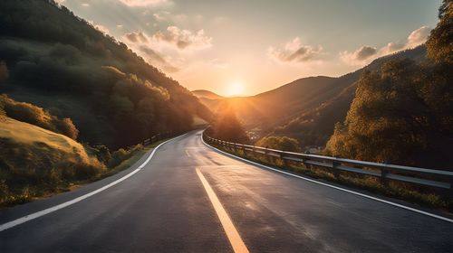 Empty road against sky during sunset