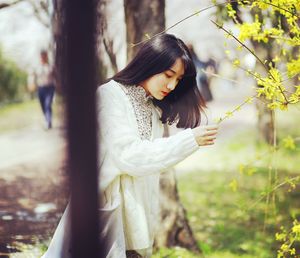 Woman standing by tree