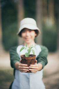 Portrait of smiling girl holding plant