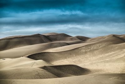 Scenic view of desert against cloudy sky