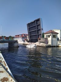 Sea by buildings against clear blue sky