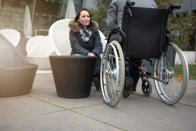 A woman talks to a disabled person in a wheelchair