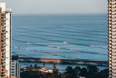 High angle view of buildings by sea against sky