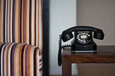 Close-up of old telephone on table at home