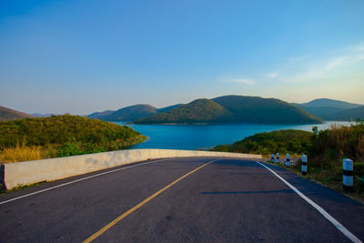 Road by mountain against blue sky