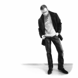 Portrait of young man standing against white background