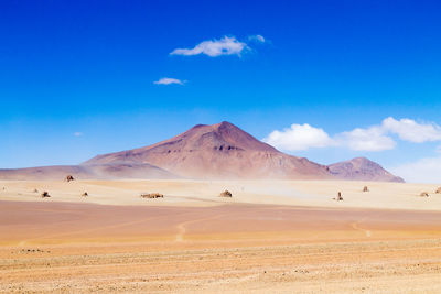 Scenic view of desert against blue sky