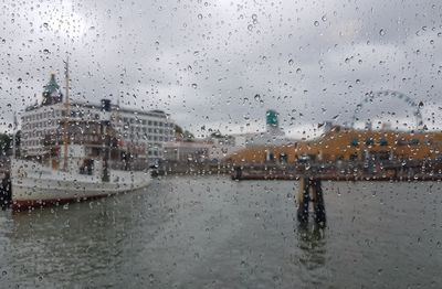 City seen through wet glass window during rainy season