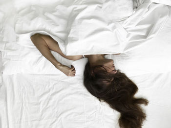 High angle view of woman sleeping on bed
