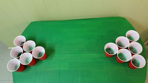 High angle view of cups arranged on table for beer pong
