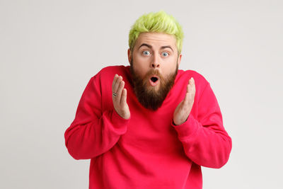 Portrait of young man standing against white background